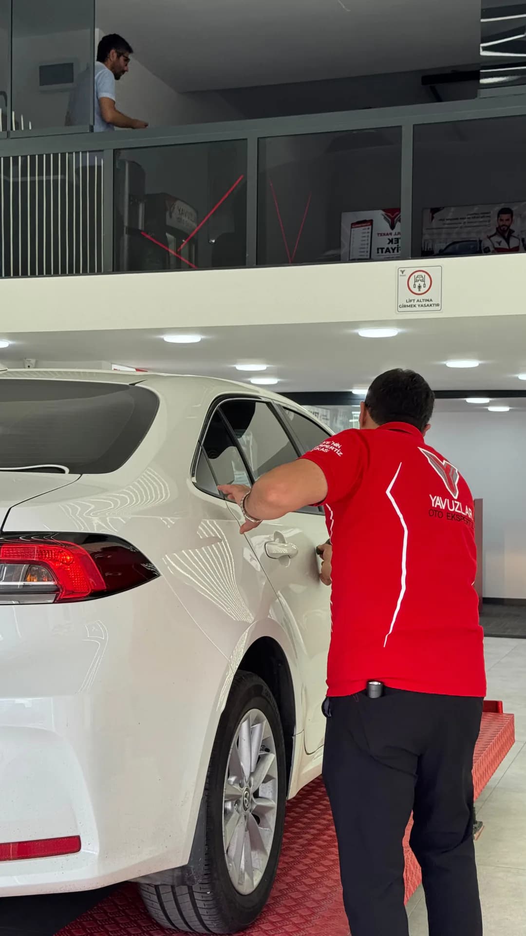 Yenikent Oto Ekspertiz — eksper aracın gövde ve kaporta kontrolünü yaparken